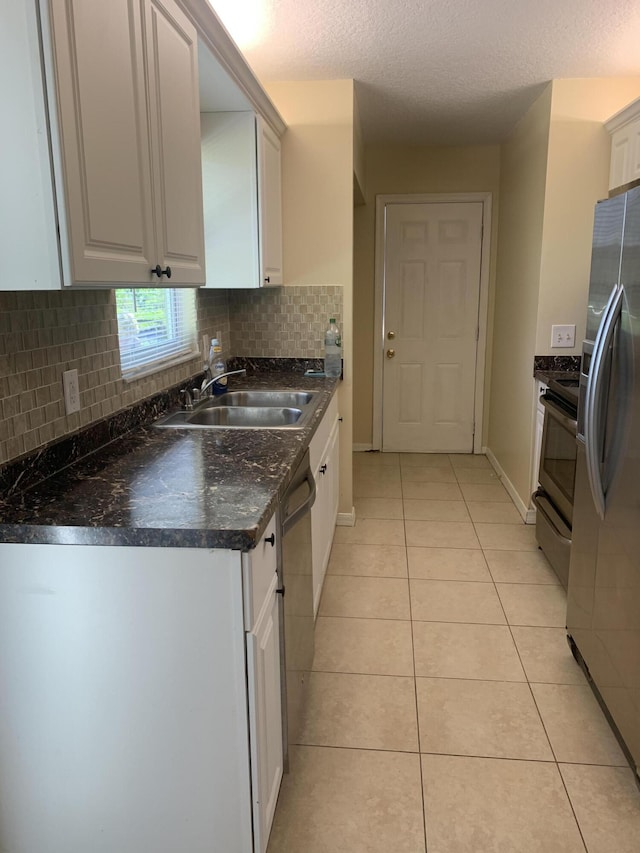 17924 W Sycamore Dr, Loxahatchee, FL 33470 - kitchen featuring stainless steel appliances, a sink, dark countertops, light tile patterned floors, and decorative backsplash