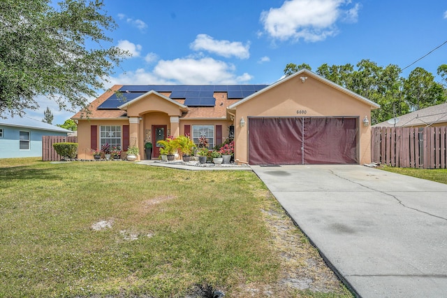ranch-style house with an attached garage, fence, a front yard, and stucco siding