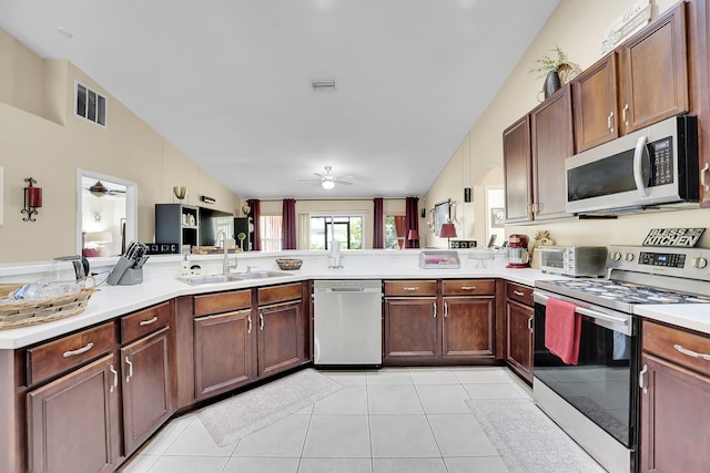 kitchen with stainless steel appliances, ceiling fan, vaulted ceiling, and a sink