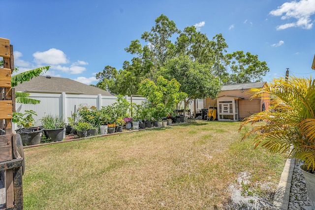 view of yard featuring fence, an outdoor structure, and a storage shed