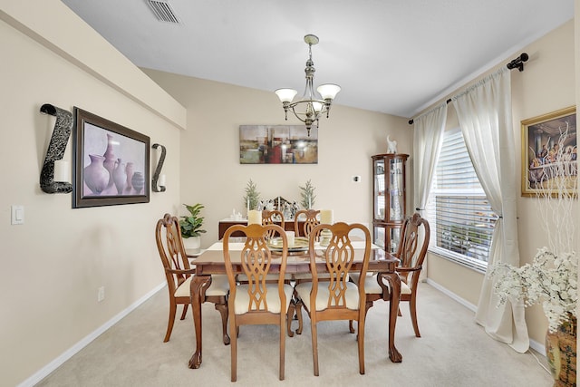 dining area featuring a notable chandelier, visible vents, light carpet, and baseboards