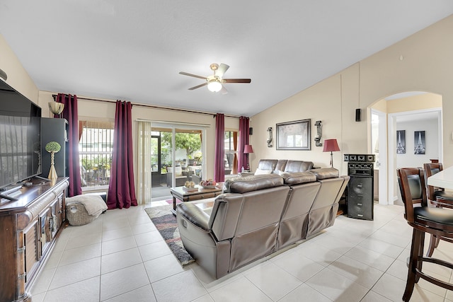living room featuring arched walkways, ceiling fan, vaulted ceiling, and light tile patterned flooring