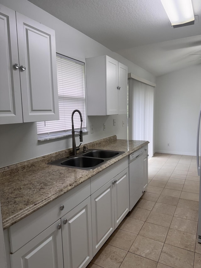 17917 49th St N, Loxahatchee, FL 33470 - kitchen featuring white dishwasher, a sink, white cabinets, light tile patterned flooring, and a textured ceiling
