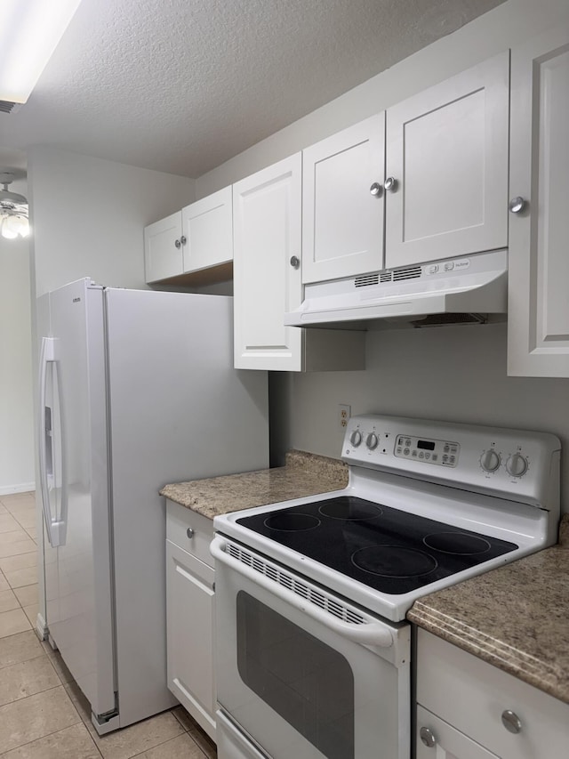 17917 49th St N, Loxahatchee, FL 33470 - kitchen with white appliances, under cabinet range hood, light tile patterned floors, white cabinetry, and a textured ceiling