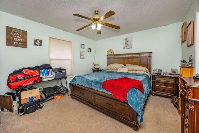 bedroom with a textured ceiling, ceiling fan, and light carpet