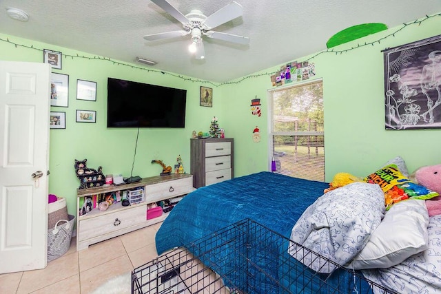 bedroom featuring tile patterned floors, ceiling fan, and a textured ceiling