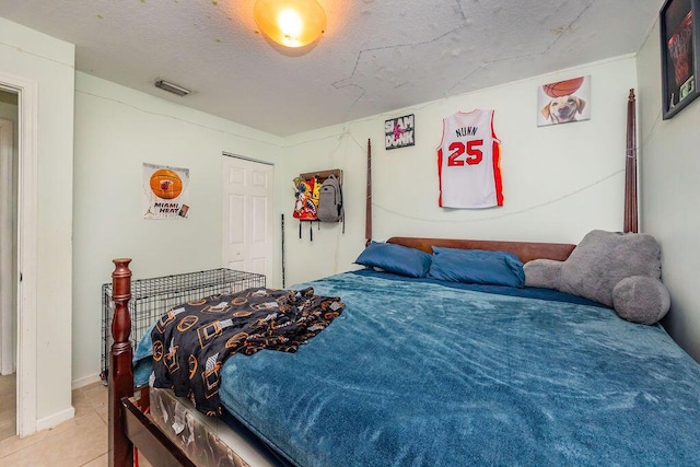 tiled bedroom featuring a closet and visible vents