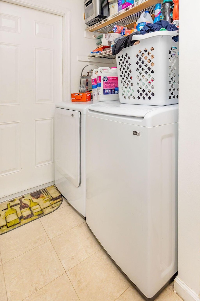 clothes washing area featuring laundry area, independent washer and dryer, and light tile patterned floors