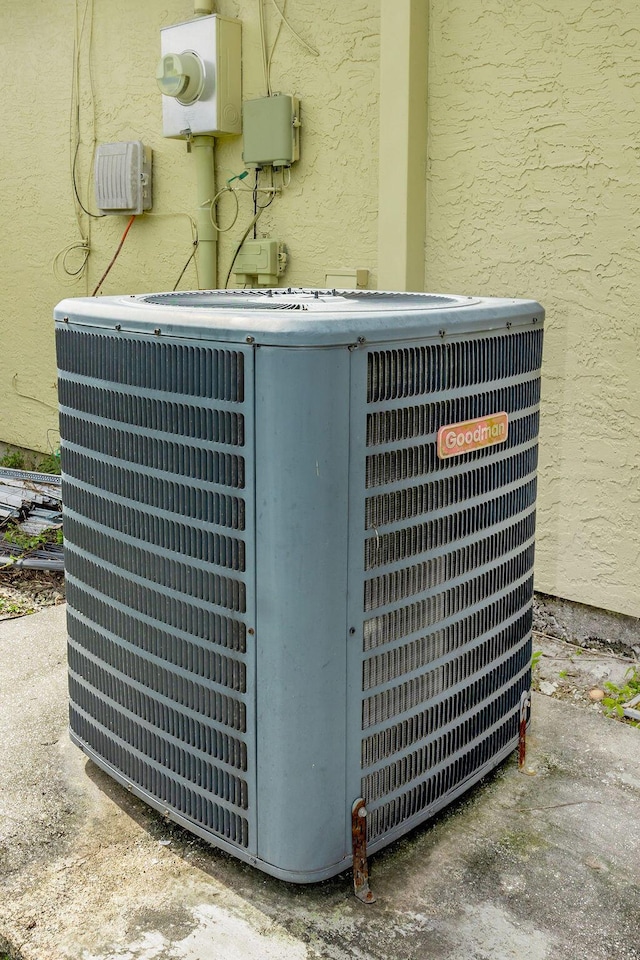 exterior details with central air condition unit, electric meter, and stucco siding