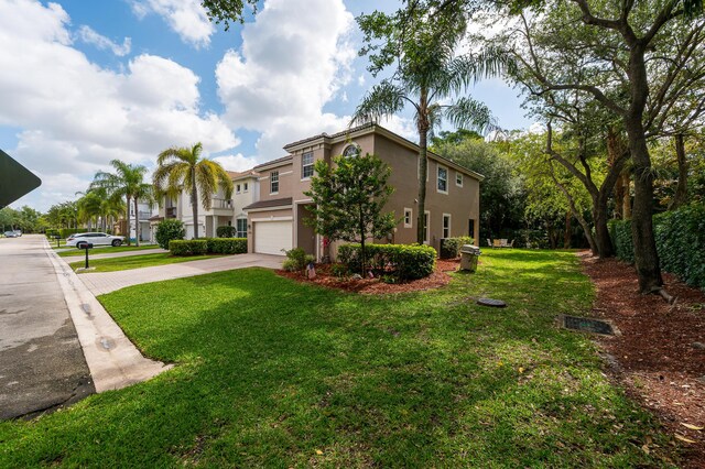21256 Via Fiore, Boca Raton, FL 33433 - view of front of property featuring concrete driveway, stucco siding, an attached garage, and a front yard