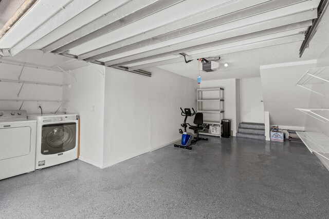 garage featuring baseboards, a garage door opener, and independent washer and dryer