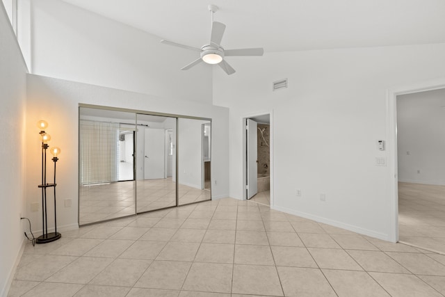 unfurnished bedroom featuring visible vents, baseboards, light tile patterned floors, and high vaulted ceiling