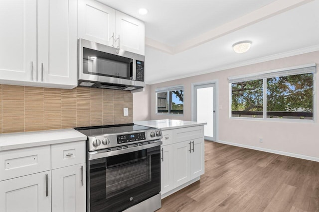 kitchen featuring tasteful backsplash, light countertops, white cabinets, baseboards, and appliances with stainless steel finishes