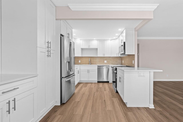 kitchen with light wood finished floors, light countertops, stainless steel appliances, and backsplash