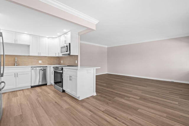 kitchen with light wood finished floors, baseboards, appliances with stainless steel finishes, decorative backsplash, and ornamental molding
