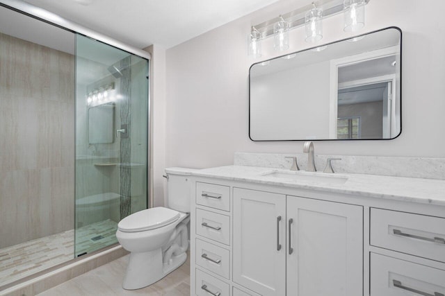 full bath with a stall shower, vanity, and toilet