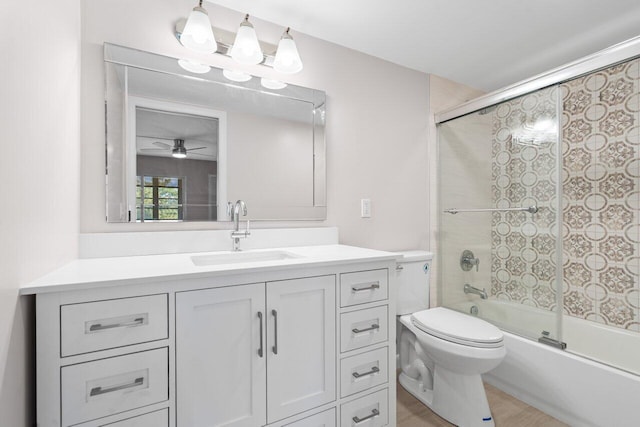 full bathroom featuring toilet, ceiling fan, shower / bath combination with glass door, vanity, and wood finished floors