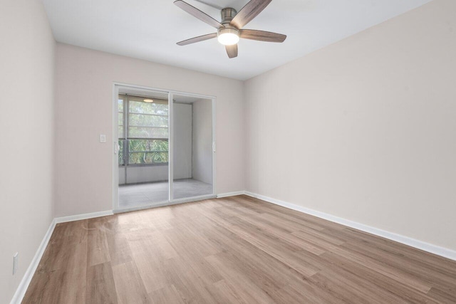 spare room featuring light wood finished floors, baseboards, and a ceiling fan
