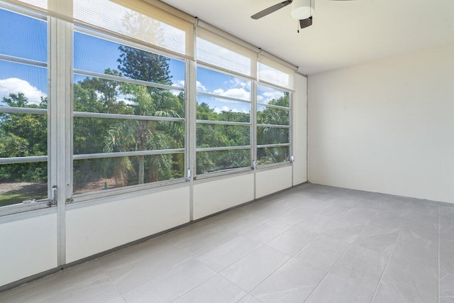 unfurnished sunroom featuring a ceiling fan