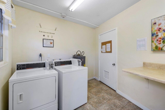 community laundry room with washing machine and clothes dryer, visible vents, baseboards, and gas water heater