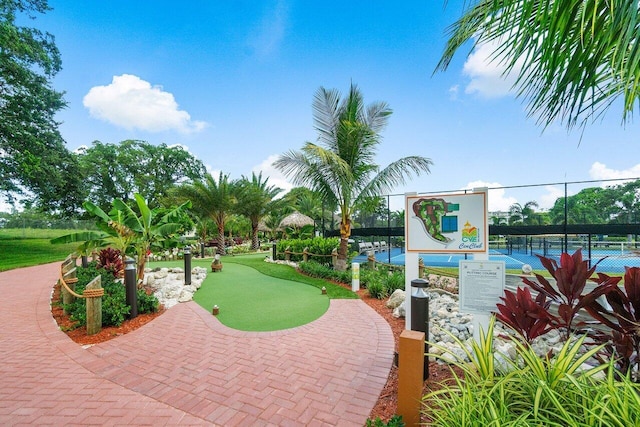 view of home's community featuring fence and a tennis court