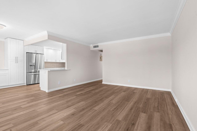 unfurnished living room featuring light wood-type flooring, crown molding, and visible vents
