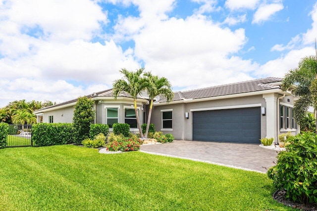 single story home with a front lawn, fence, decorative driveway, stucco siding, and an attached garage