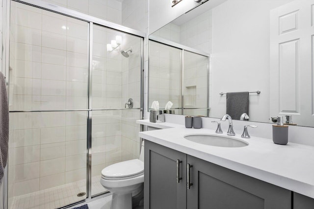 full bath featuring vanity, a stall shower, and toilet
