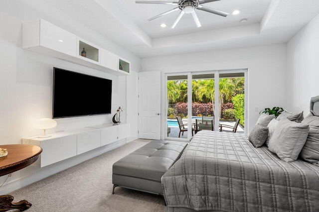 carpeted bedroom featuring access to outside, a tray ceiling, recessed lighting, and ceiling fan