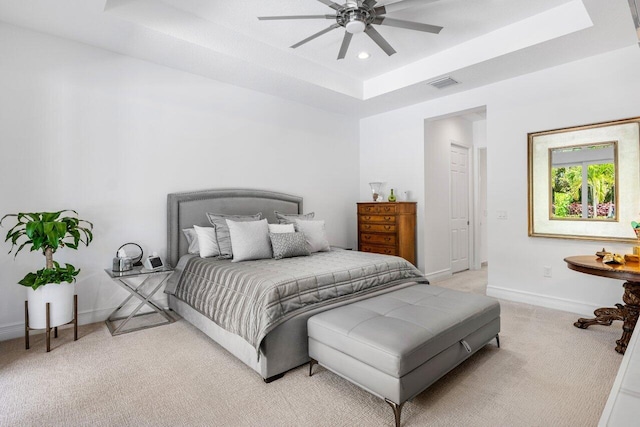 bedroom with visible vents, baseboards, light carpet, a tray ceiling, and recessed lighting