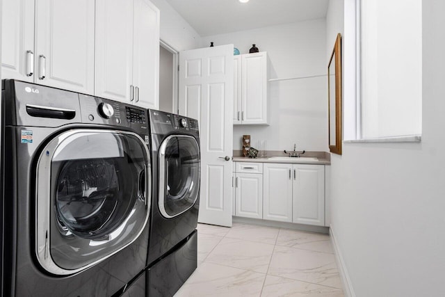 washroom featuring cabinet space, a sink, marble finish floor, baseboards, and washer and clothes dryer
