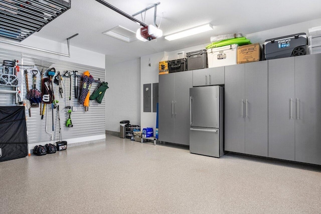 garage featuring freestanding refrigerator, a garage door opener, and electric panel