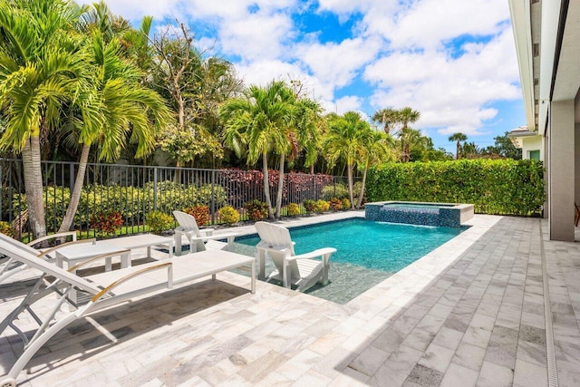 view of pool with a pool with connected hot tub, fence, and a patio area