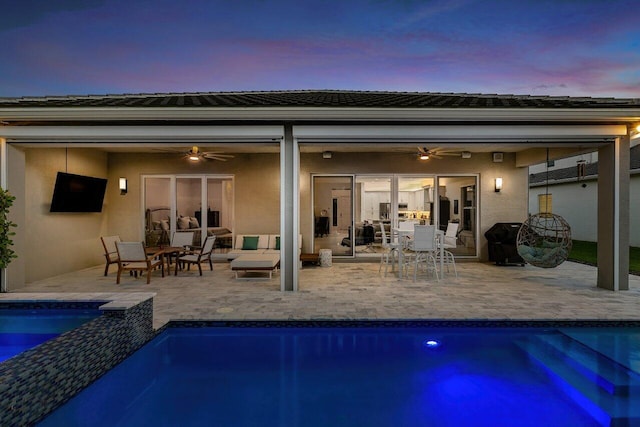 back of house featuring a pool with connected hot tub, ceiling fan, stucco siding, outdoor lounge area, and outdoor dining area