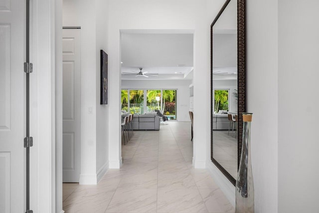 hallway featuring baseboards and marble finish floor