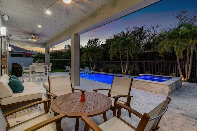 view of swimming pool with a fenced backyard, a ceiling fan, outdoor dining space, and an in ground hot tub