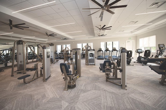 exercise room featuring light carpet, a ceiling fan, and visible vents