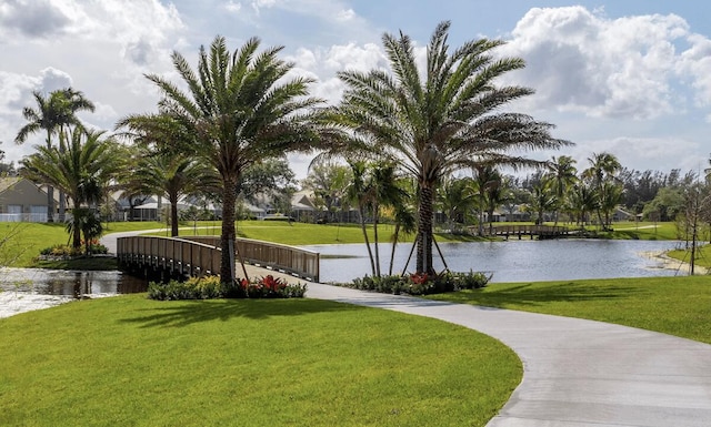 surrounding community with a yard and a water view