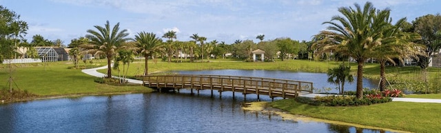 view of home's community with a lawn and a water view