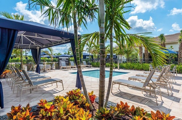 pool with a gazebo, a patio area, and fence
