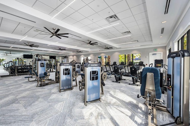 gym with ceiling fan, visible vents, light carpet, and a paneled ceiling