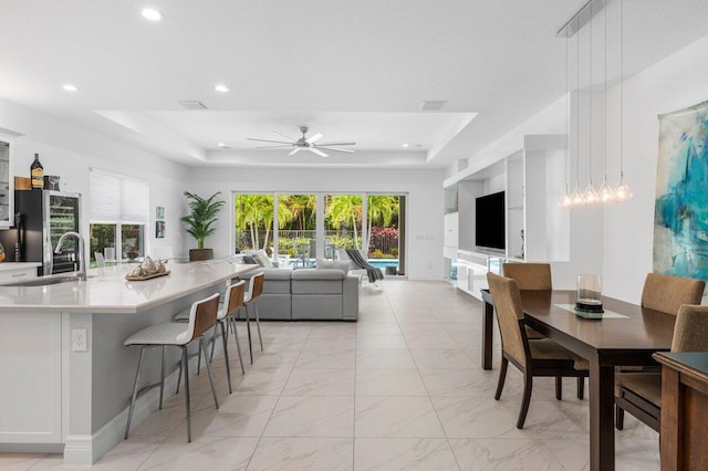 interior space featuring recessed lighting, a tray ceiling, and ceiling fan