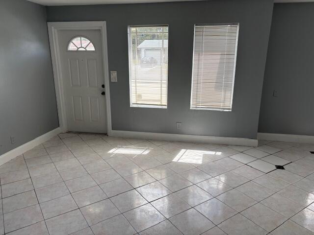 entrance foyer with baseboards and light tile patterned flooring