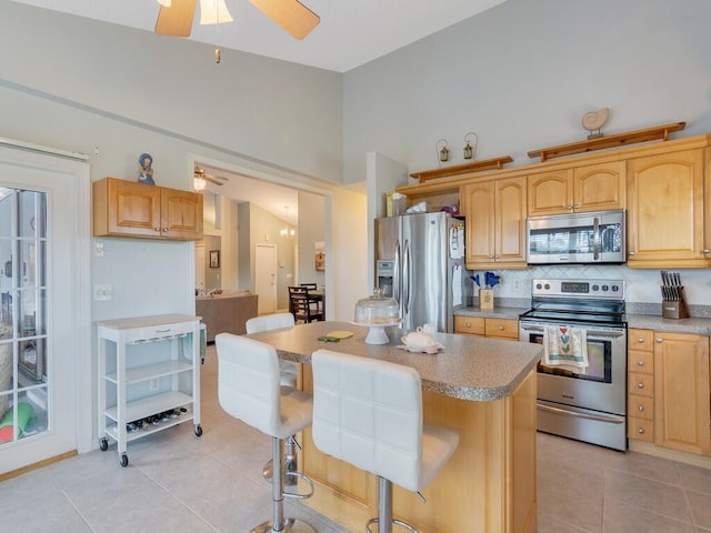 kitchen featuring light countertops, a ceiling fan, appliances with stainless steel finishes, and light tile patterned floors