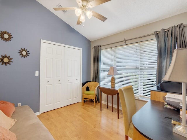 office space with baseboards, ceiling fan, light wood finished floors, and lofted ceiling