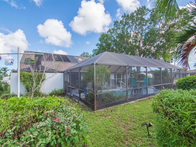 outdoor pool featuring a lawn