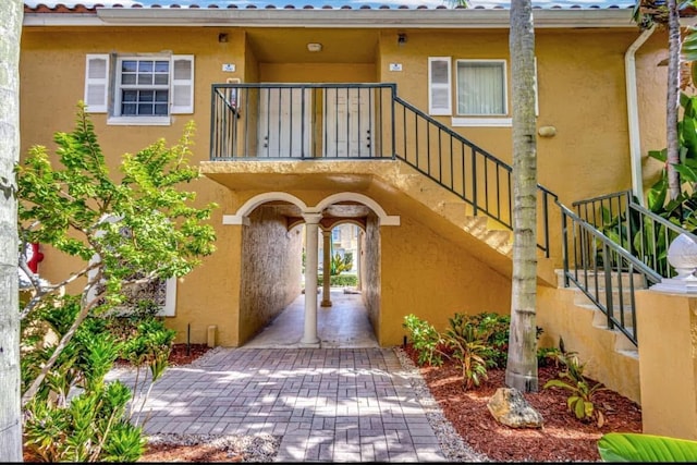 1120 Lake Shore Dr Unit 206, Lake Park, FL 33403 - property entrance with a balcony and stucco siding