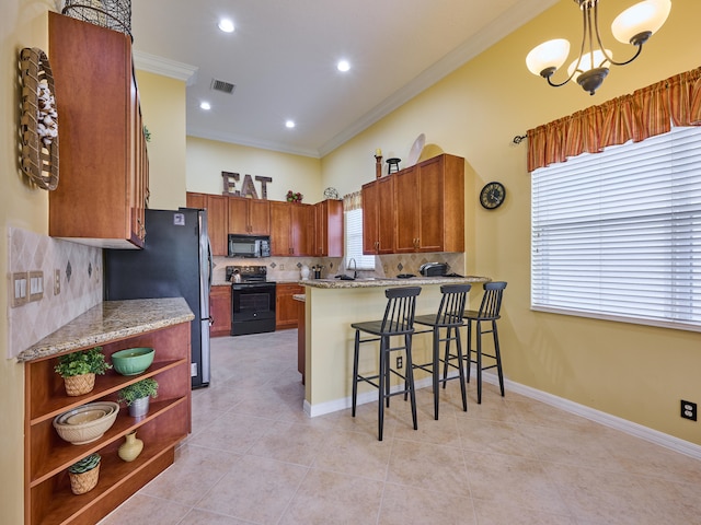 kitchen with visible vents, black appliances, a peninsula, a chandelier, and ornamental molding