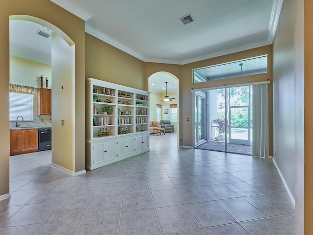 spare room featuring visible vents, a sink, crown molding, and arched walkways