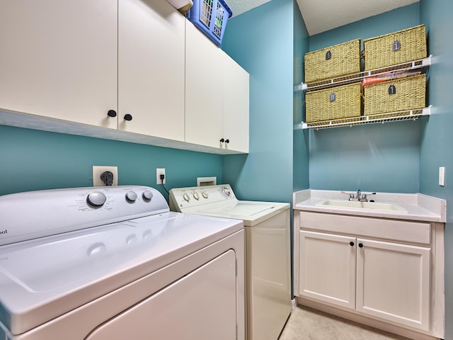 laundry area featuring cabinet space, a sink, and washing machine and clothes dryer